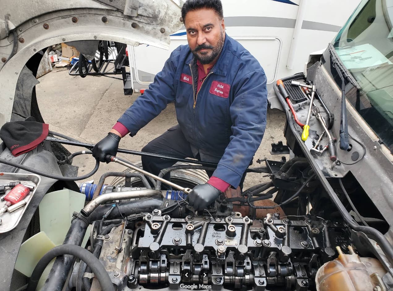 Technician performing electrical diagnostics on a commercial truck